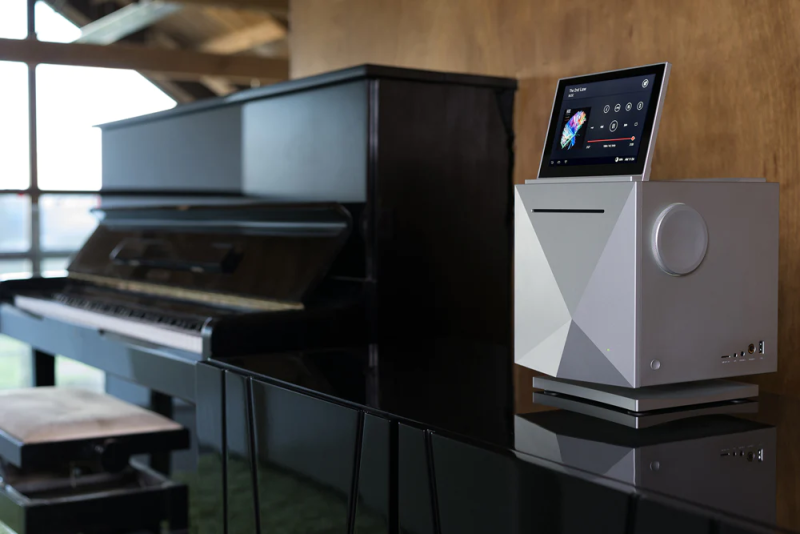 Astell&Kern AK500N network media player placed next to a piano in a modern living room