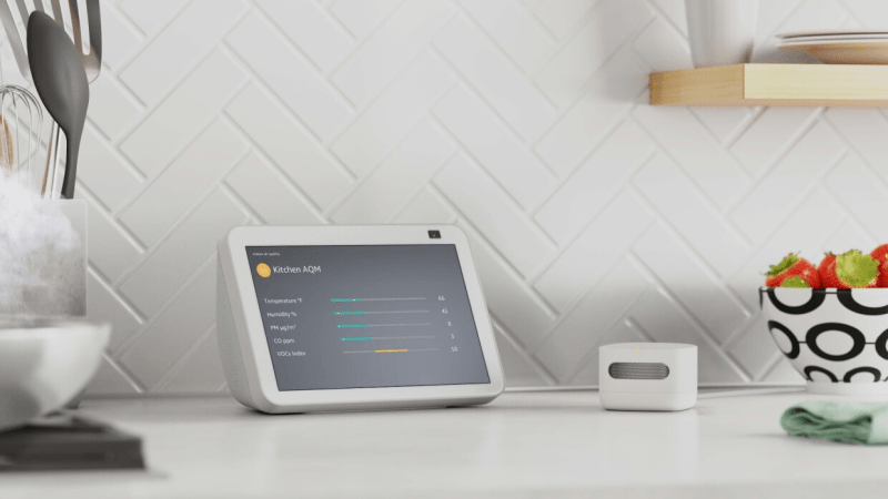 Amazon Smart Air Quality Monitor positioned on a kitchen counter next to an Echo device