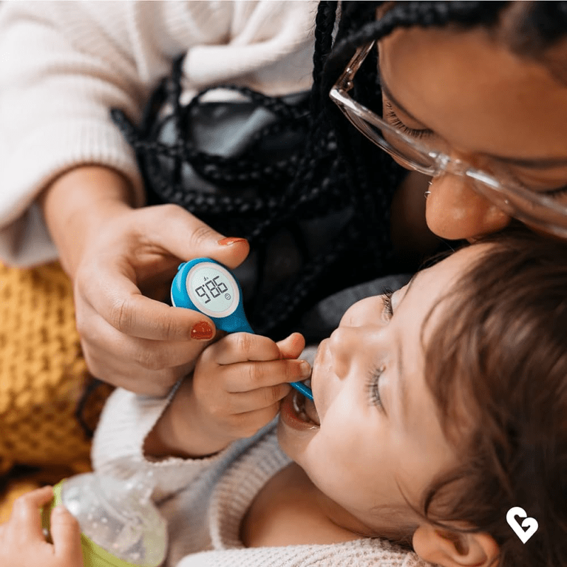 Mother using Kinsa Smart Thermometer on her child's mounth
