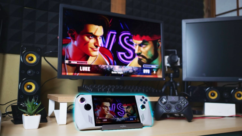 ASUS ROG Ally handheld gaming device on a desk in a vibrant gaming room setup.