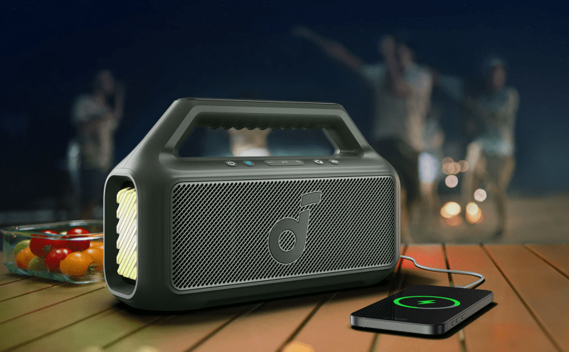 Outdoor speaker charging a smartphone outdoors.