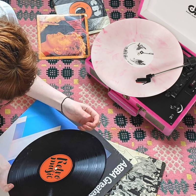 Individual holding vinyl record while enjoying music from the DANFI AUDIO DF Vintage Record Player