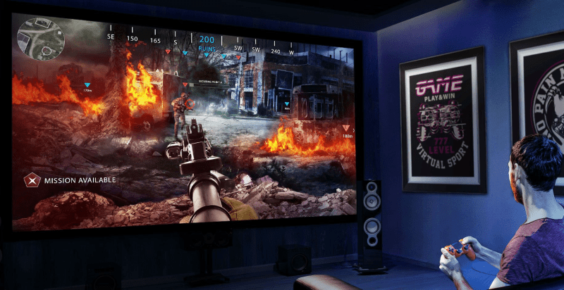 Person playing a game on BenQ X3100i projector with game projection visible