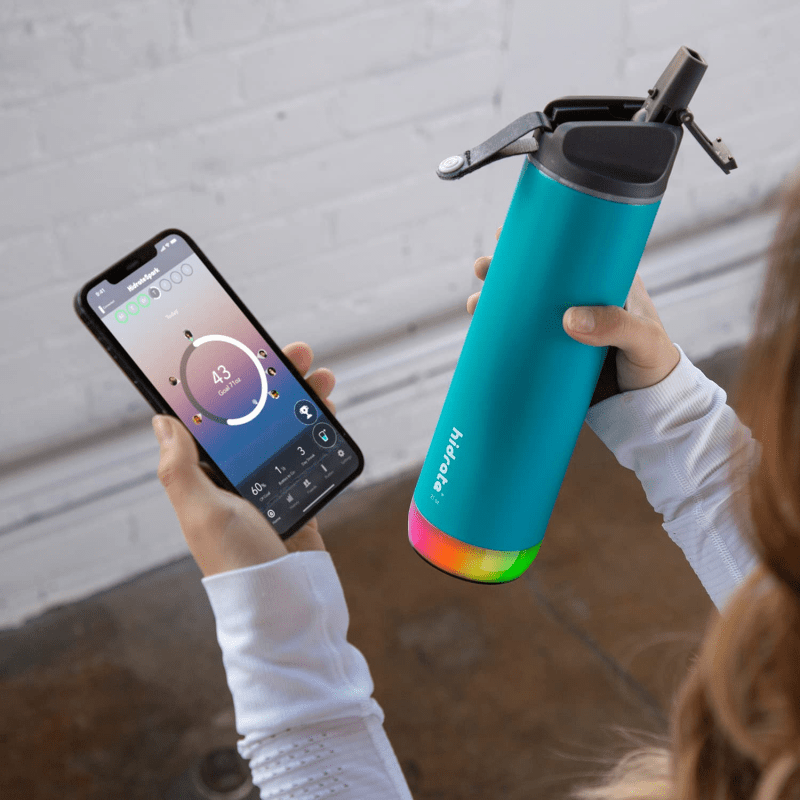 Person's hands holding Hidrate Spark PRO bottle while checking the app