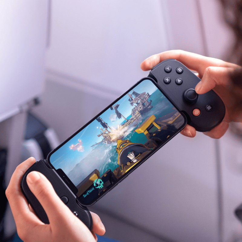 Adult playing a game on a mobile device using the BACKBONE One controller at home.