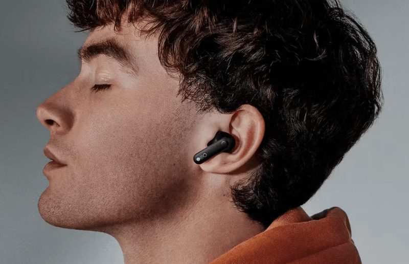 Male model wearing CMF Buds wireless earbuds.