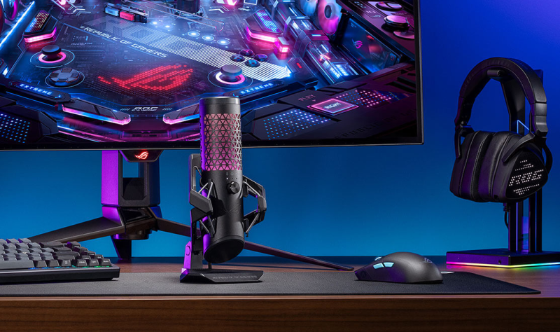 ASUS ROG Carnyx microphone positioned in a gaming setup with RGB lighting.