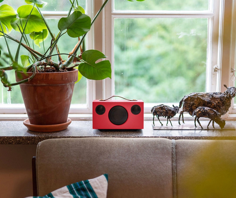 Colorful Bluetooth speaker placed in a modern room setting.