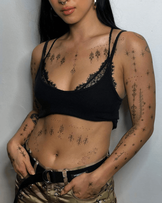 Woman showcasing multiple temporary tattoos applied by Prinker S.