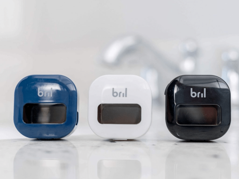 Three Bril UV-C toothbrush sanitizers in various sizes and colors.