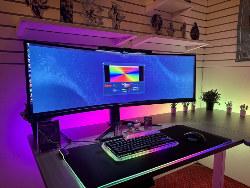 The HYTE Keeb TKL keyboard displaying its full RGB lighting in a dark room, illuminating its surroundings.