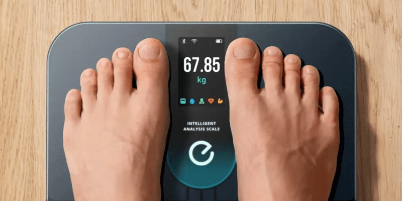 A person stepping onto the eufy Smart Scale P3 while checking progress on their smartphone