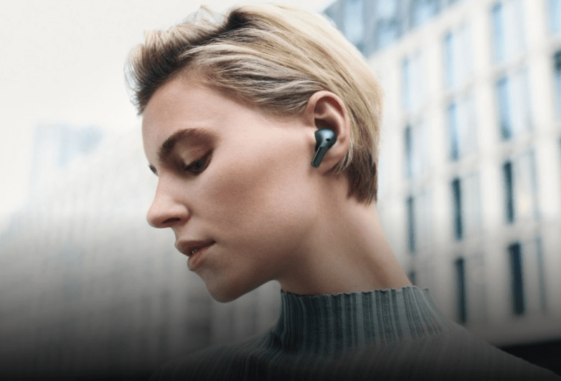 A person wearing OnePlus Buds Pro 3 in a café, enjoying crystal-clear calls with noise cancellation.