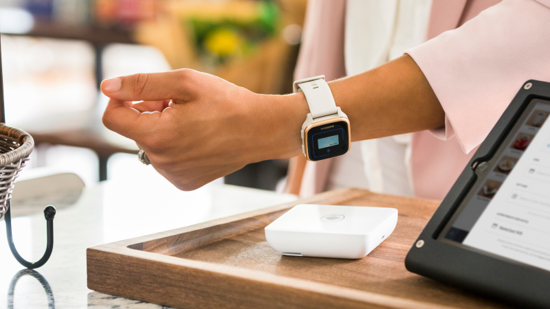 Garmin Venu® Sq 2 being used for a contactless payment at a store.