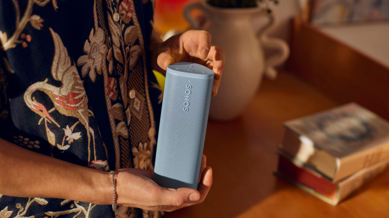 A person's hand holding the lightweight Sonos Roam 2 speaker, showcasing its portability.