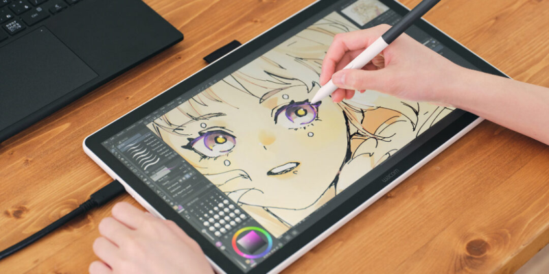 A close-up macro shot of the Wacom MovinkPad Pro 14 screen, showing the tip of the Pro Pen 3 drawing a vibrant, colorful line on the deep black OLED surface.