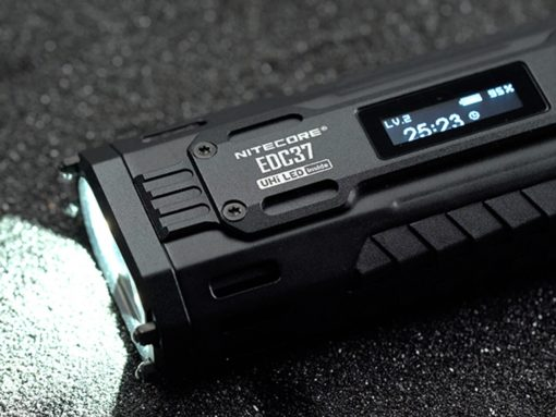 A top-down view of the Nitecore EDC37 in a hand, focusing on the lit-up OLED screen showing "8000 lm" and the battery level, with the Rapid Lock slider visible next to it.